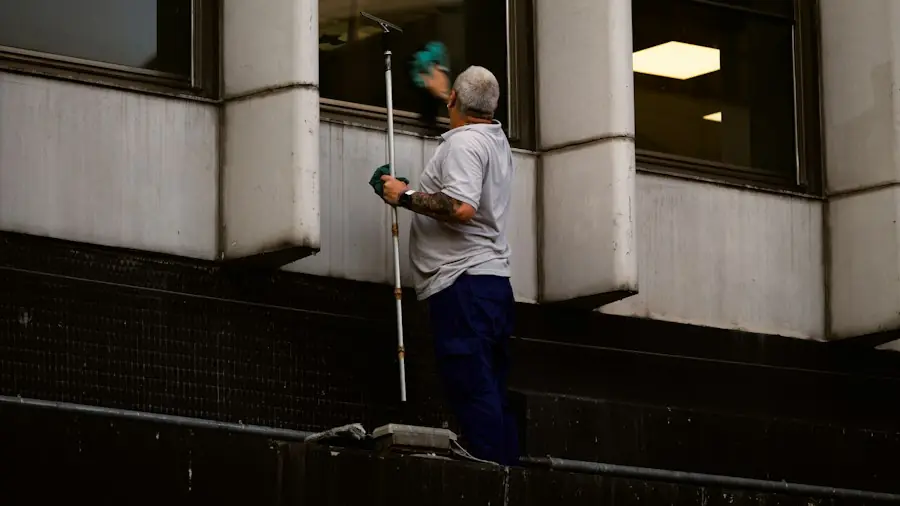 Professional window cleaner washing exterior glass with a pole